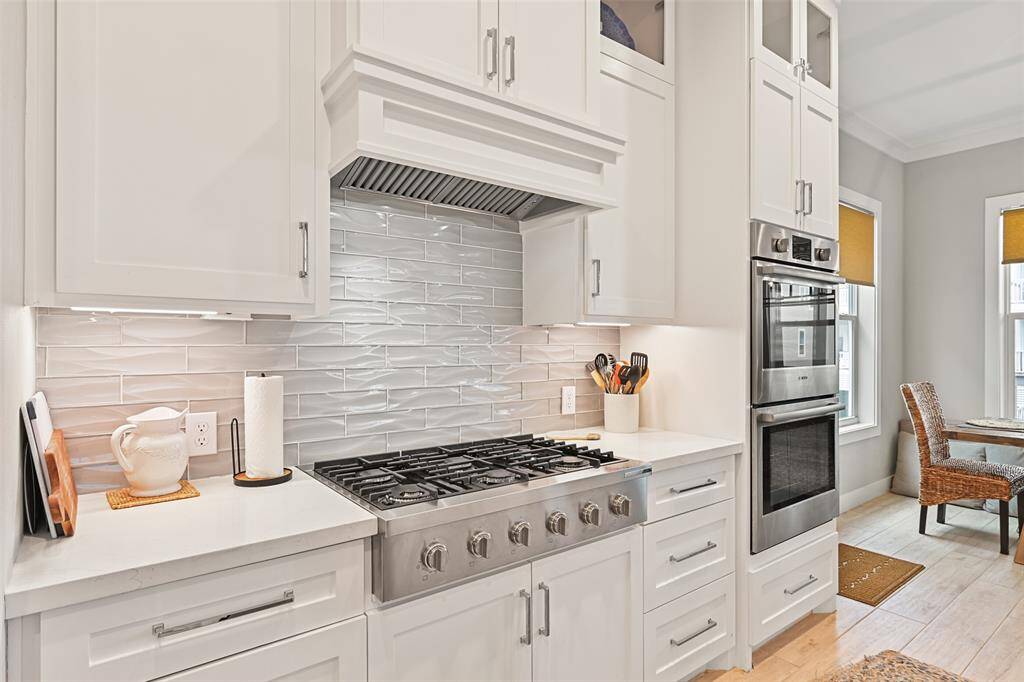 Sleek BOSCH stainless-steel stovetop and custom hood for the cook in the family!  Notice the double oven for the big family gatherings.  Look at the tile deatail.