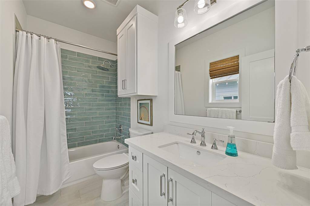 This is the guest bedroom ensuite. Note the custom tile in the shower/tub combo, modern fixtures and ample storage in the custom-cabinetry make this bathroom the perfect combination of luxury and convenience.