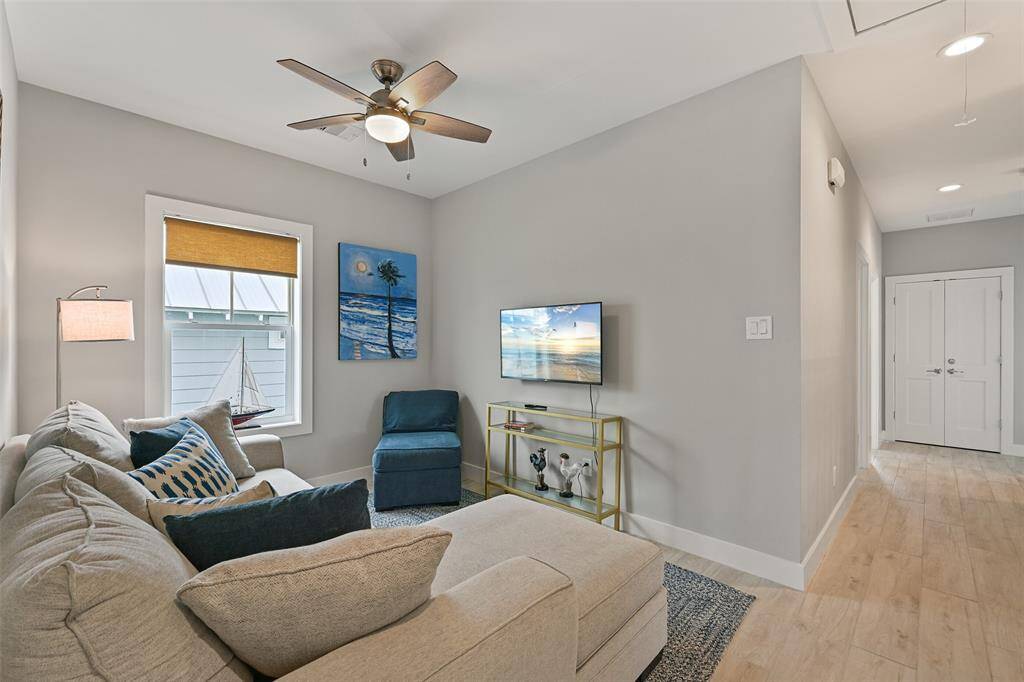The upstairs den offers endless possibilities in this spacious flex room—perfect for a home office, gym, media room, or guest retreat to suit your lifestyle needs!  The sofa is a pull out for extra guests.  The two guest rooms are down the hall and the bunk room is across the hall.  Notice the ELEVATOR door access in the hallway. (ELEVATOR NOT included, but the shaft is there acting as a closet).