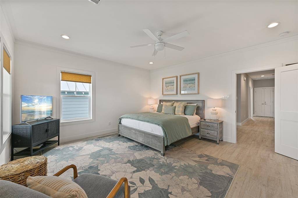 Another angle of the expansive primary suite offering ample natural light, top floor patio access, and a luxurious ensuite bathroom.