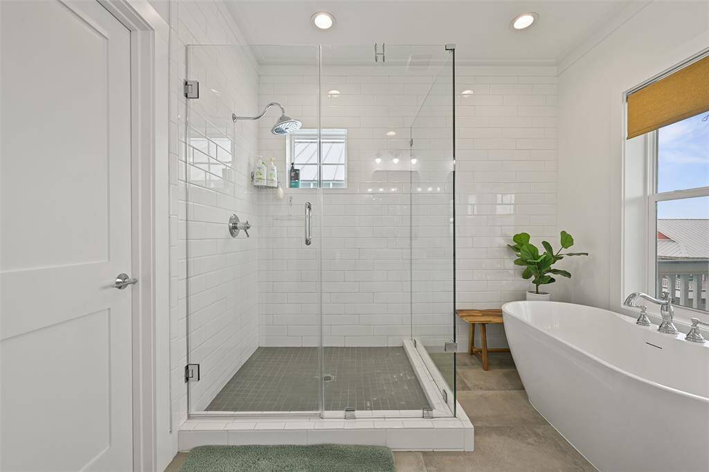 Luxurious ensuite with double vanities, soaking tub, and walk-in shower.  To the right is a large walk in closet.  Notice the window in the shower- enjoy lights of the causeway when taking an evening shower!