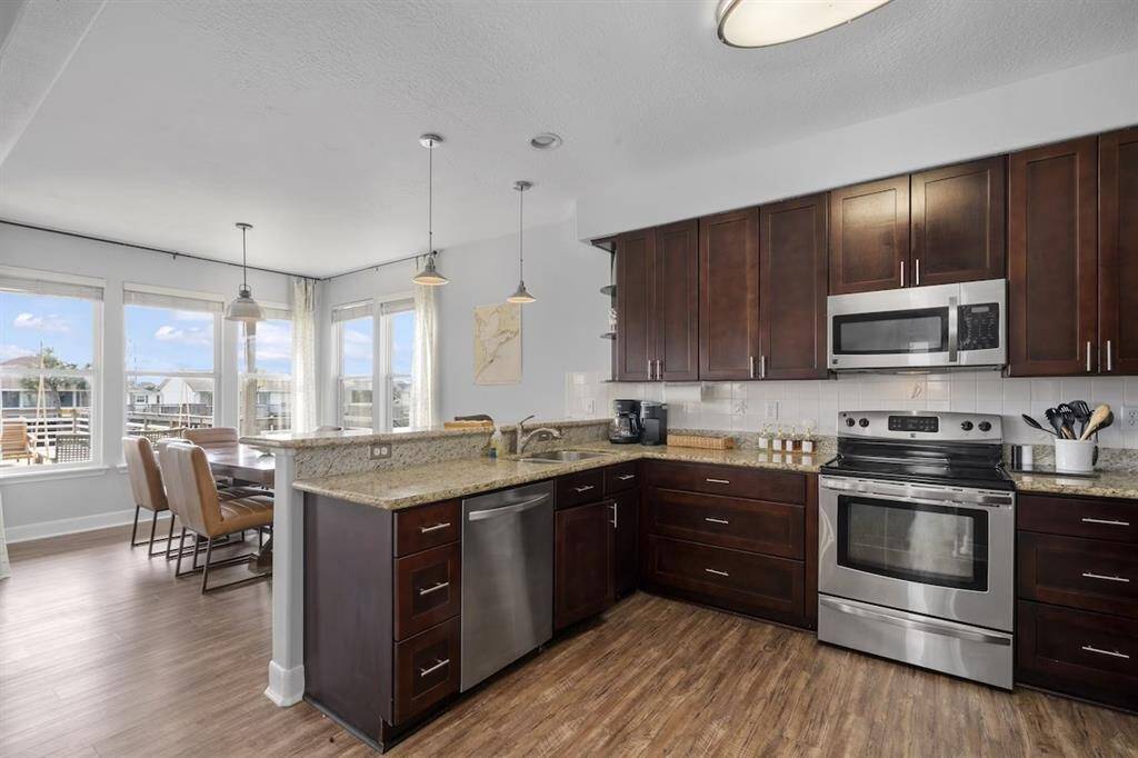 The kitchen opens offers a breakfast bar, and stainless steel appliances.