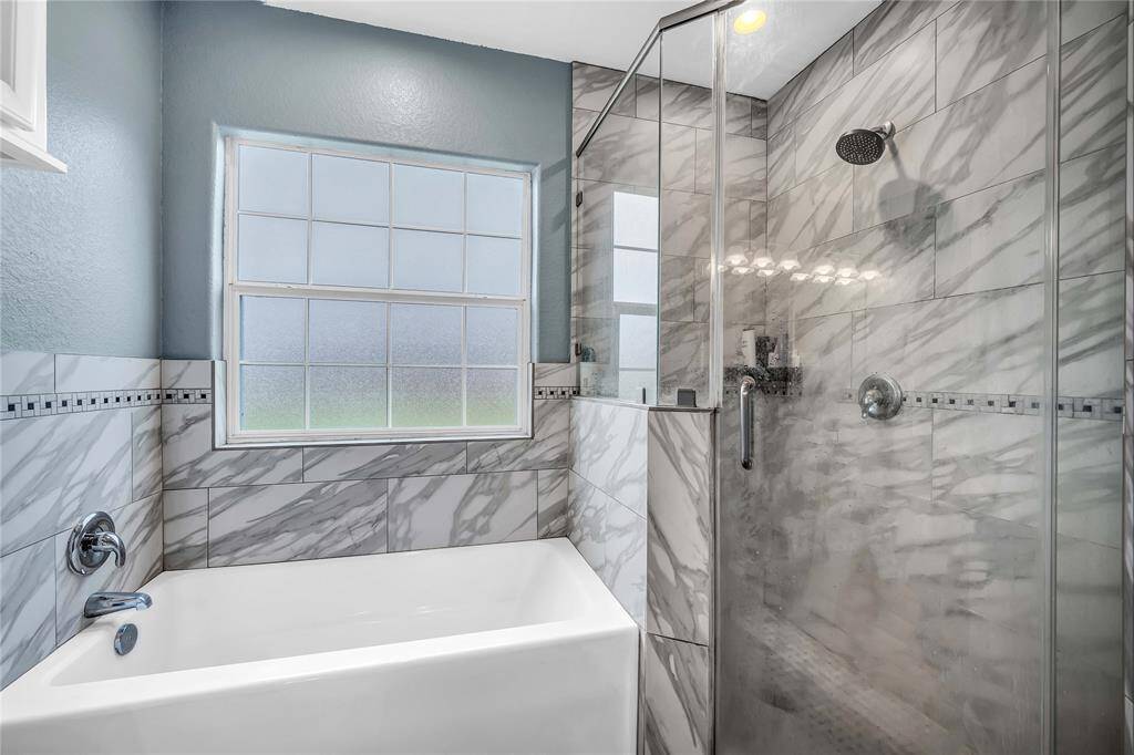 Primary bath includes a large soaking tub and separate glass shower.