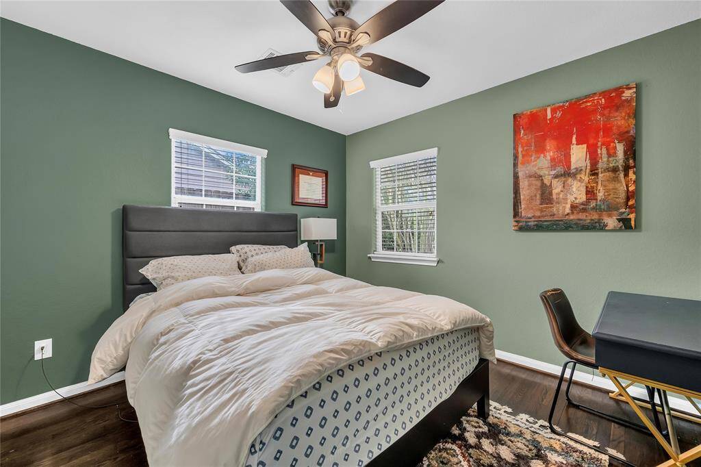 Secondary bedroom with hardwood floors and ceiling fan.