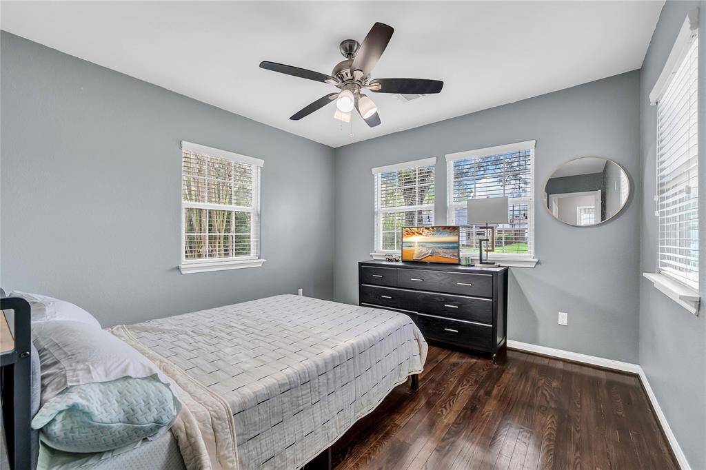 Secondary bedroom with hardwood floors and multiple windows allowing for plenty of natural light.