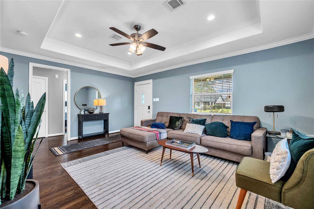 Light and bright living room with hardwood floors, ceiling fan, and recessed lighting.