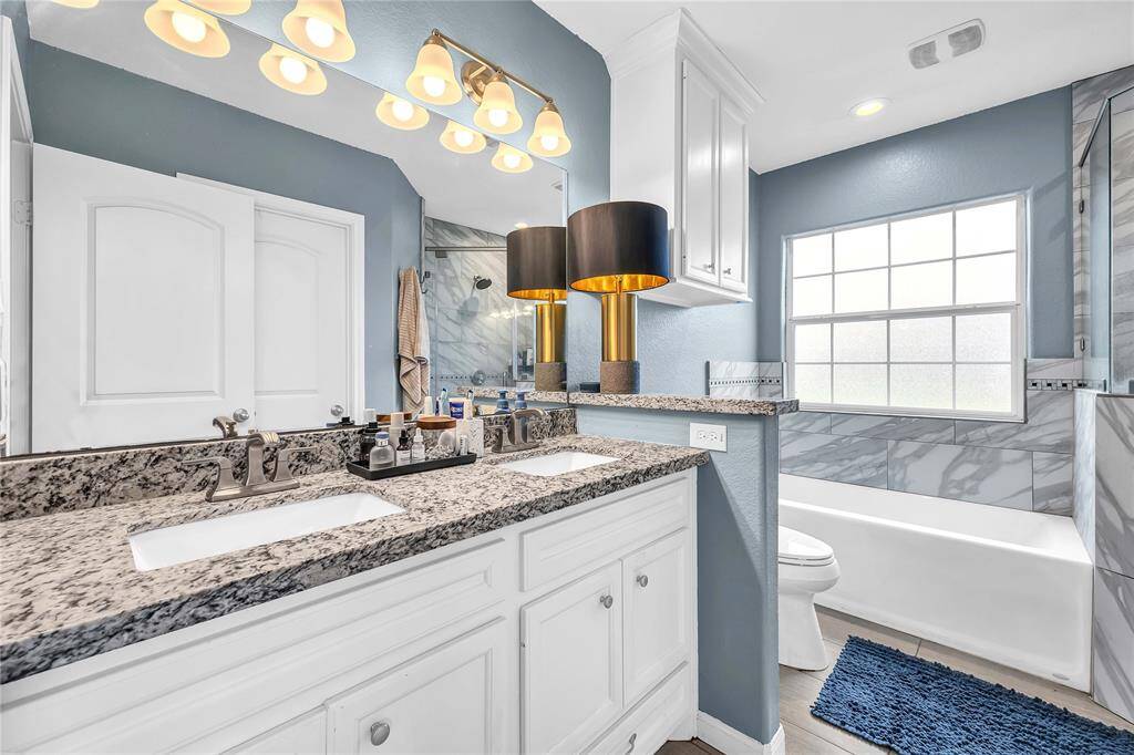 Primary bath with double sink vanity and custom cabinetry with plenty of storage.