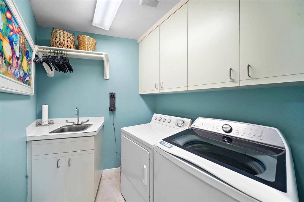 Efficient utility room with sink and hanging space. Washer and dryer included.