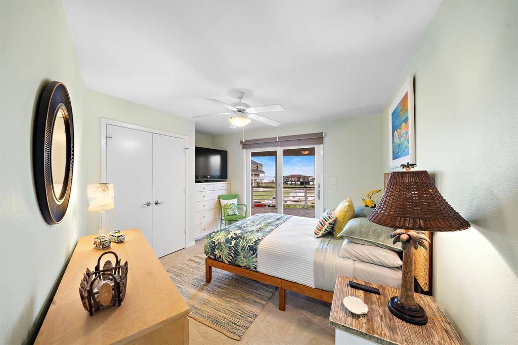 Guest bedroom with built in storage and TV.  All bedrooms have sliding glass doors to balcony and privacy blinds.
