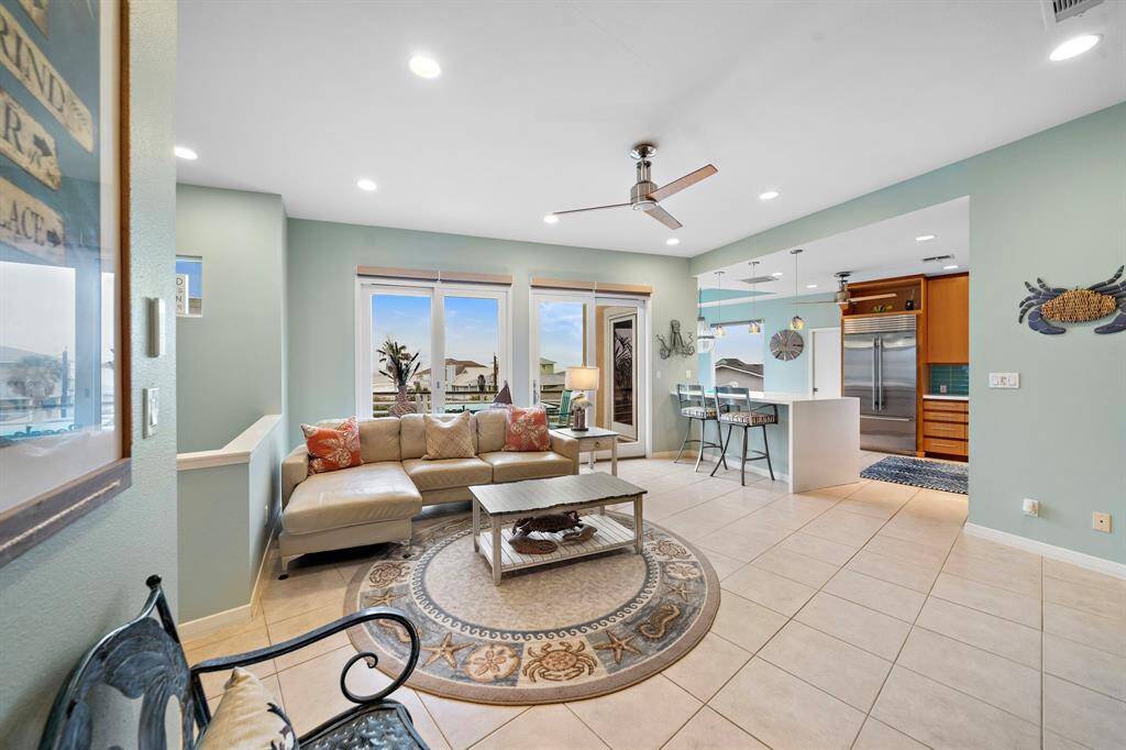 Beautiful Living space open to the kitchen with tile floors, recessed lighting, and remote controlled custom blinds.