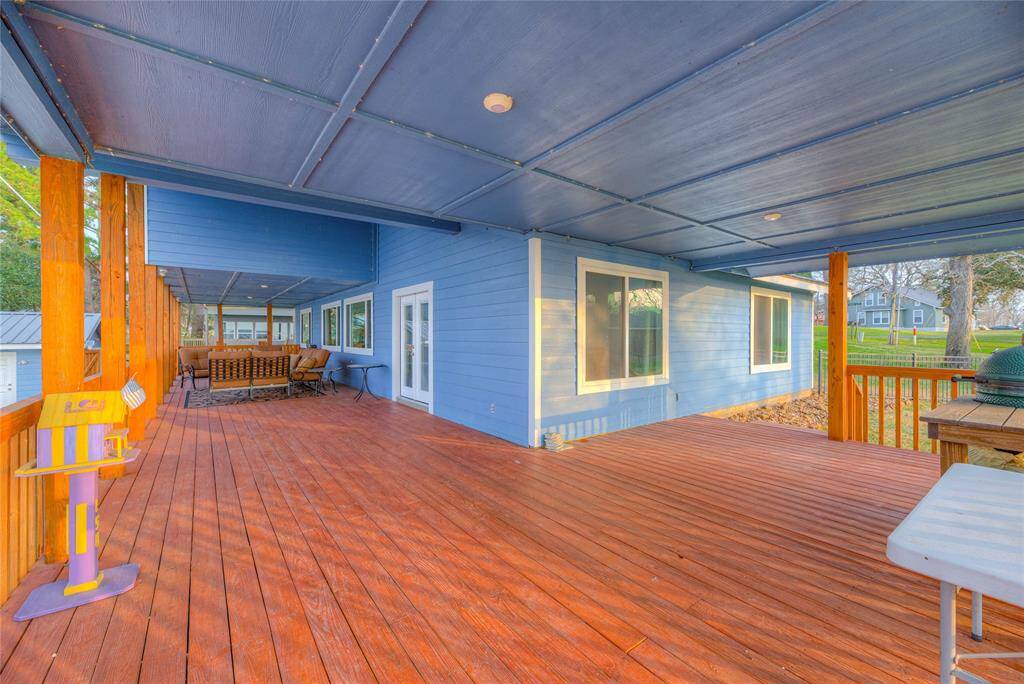 Covered back and side deck overlooking the pool & lake.