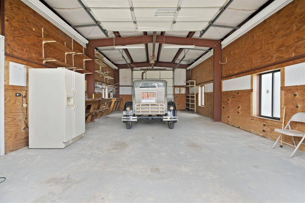 Spacious RV and workshop garage featuring a car lift and an automatic garage door opener. Antique car not included