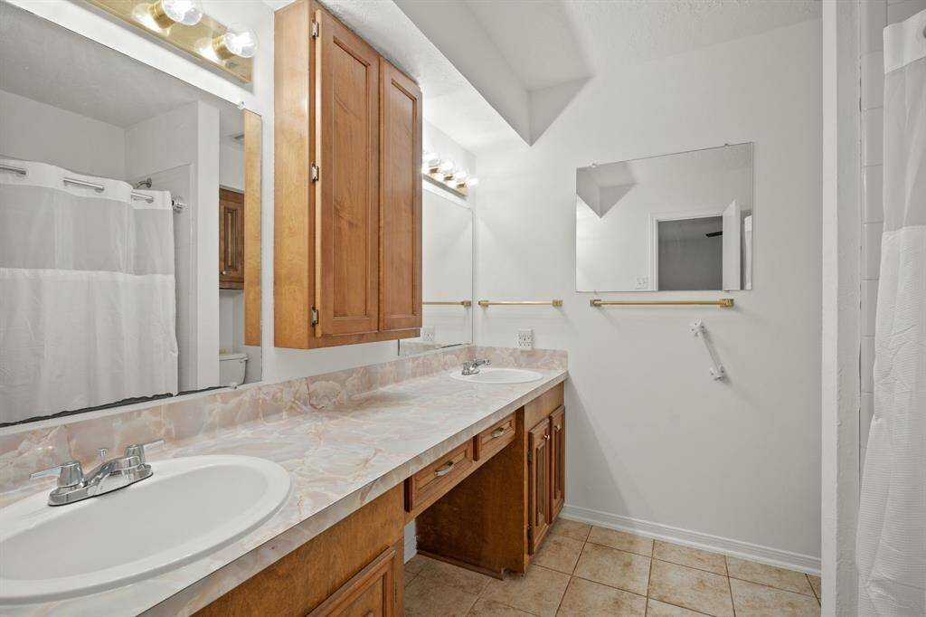 Ensuite bathroom with large vanity, double sinks, and shower.
