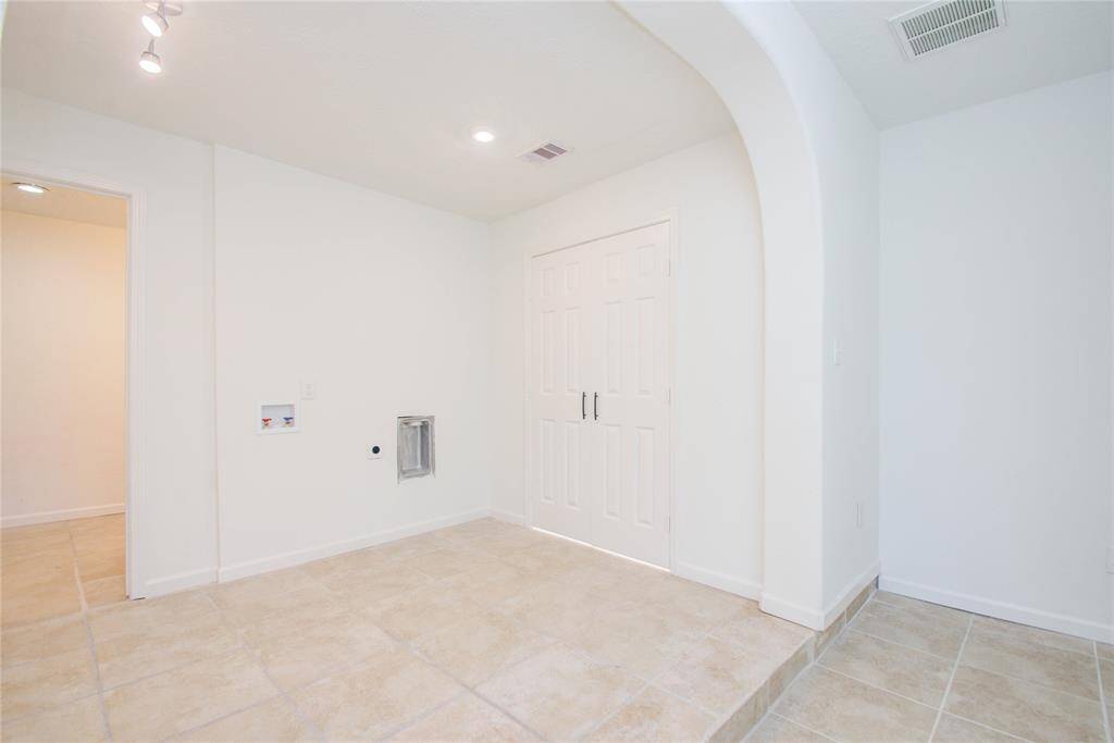 Primary Bedroom includes area with Washer and Dryer Connections.  Door to large Primary Bathroom is open to the left of connections.