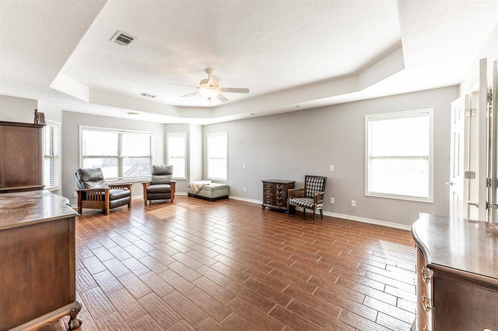 spacious primary bedroom with rounded tray ceiling