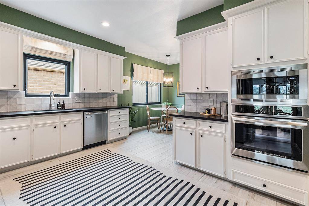 Another view of the kitchen showing off the stainless steel appliances and adjacent breakfast area