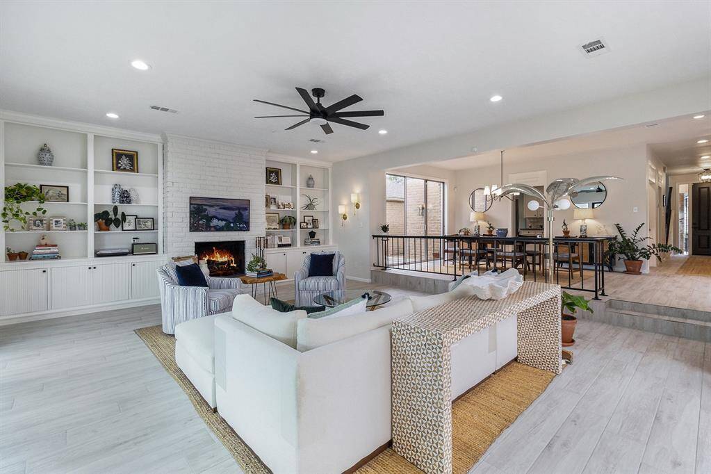 Living room adjacent to the dining area separated by more elegant metal railing.