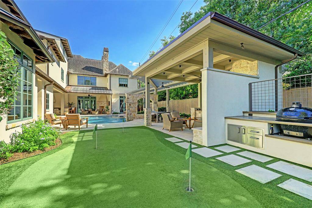 The backyard is complete with a putting green and a Myron Mixon smoker.