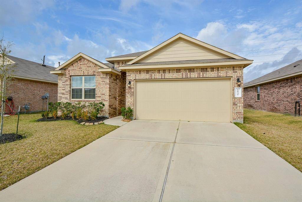 This charming, single-story brick home with a two-car garage. It features a well-maintained front lawn with shrubs and a clean driveway. The exterior has a classic and inviting look, perfect for a family.