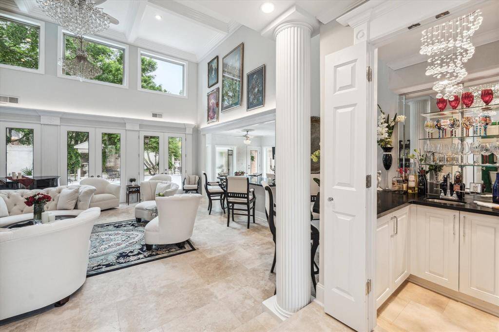 LIVING ROOM- Grandiose living room with high ceilings, windows and wet bar. Ideal for entertaining.