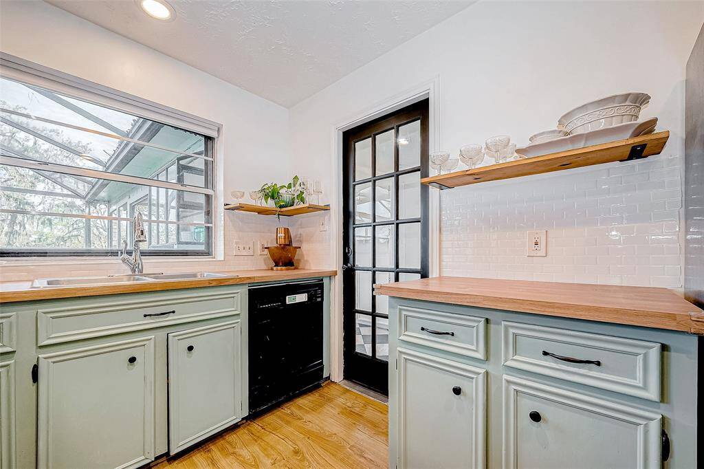 This kitchen is complemented by a classic black-framed glass door which leads into the expansive sunroom