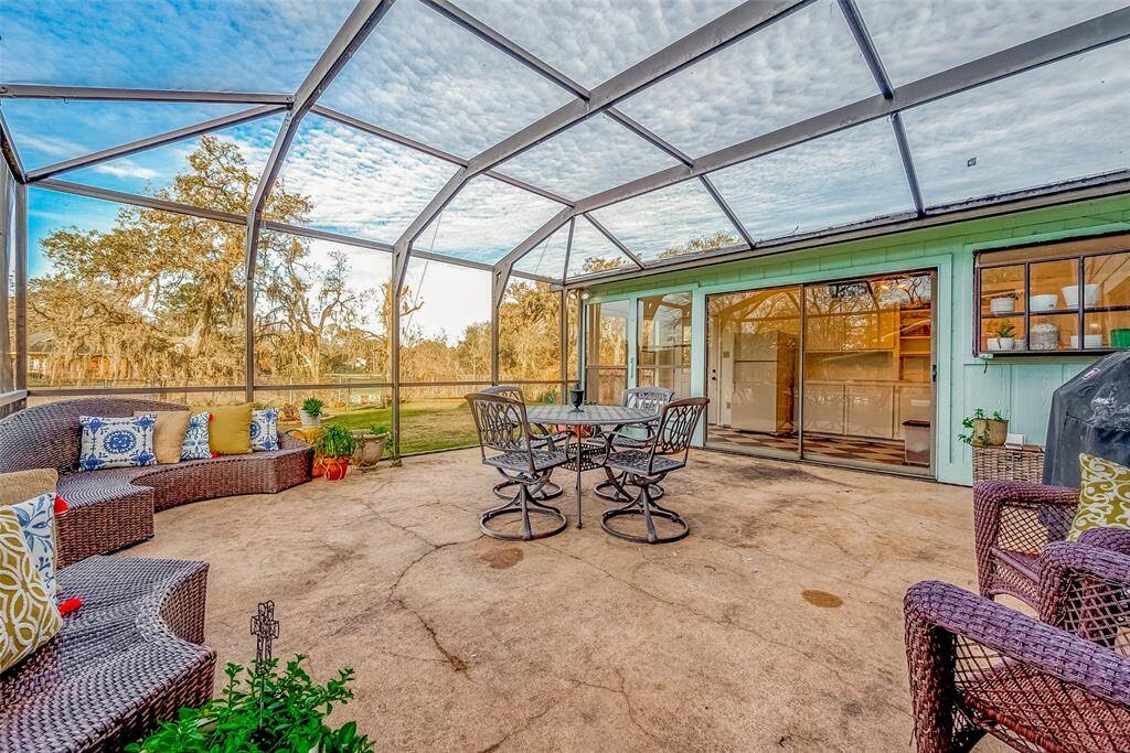Spacious screened-in patio perfect for outdoor relaxation and entertaining. Offers access to the interior through large sliding glass doors.