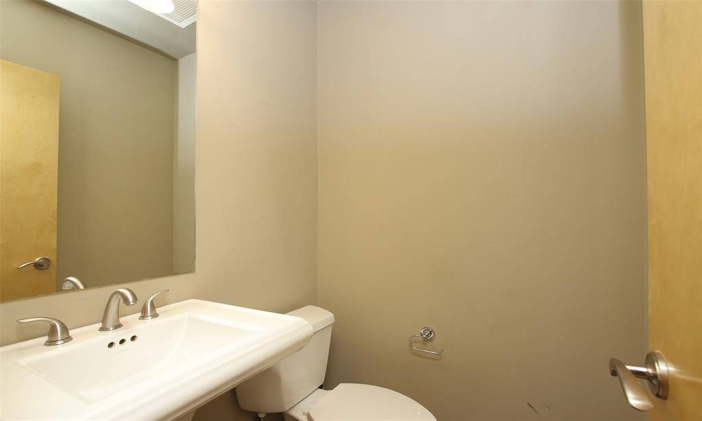 Half bath is located on the first floor off of the entry hall. Slate tile flooring and pedastol sink.
