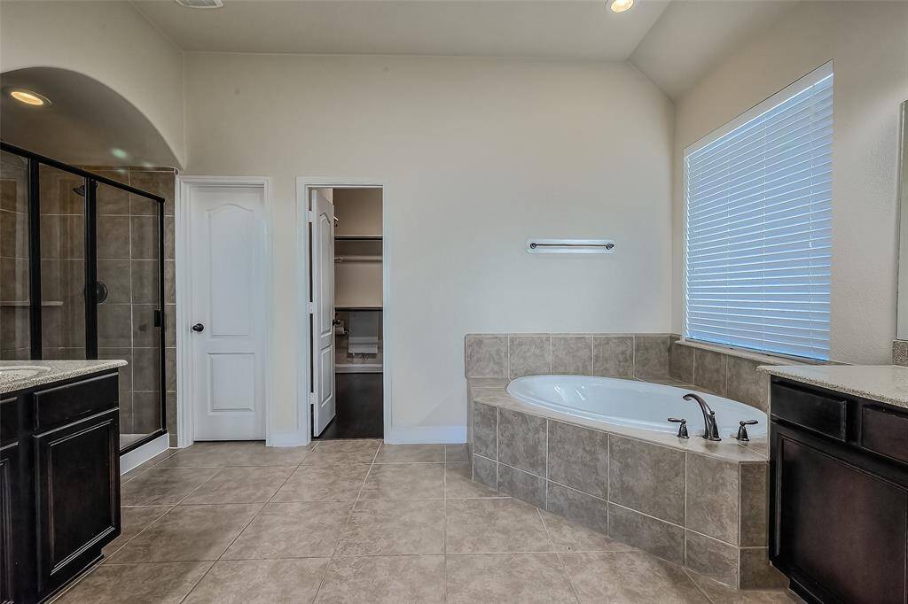 Plenty of space in primary bathroom with his and hers sinks and large closet