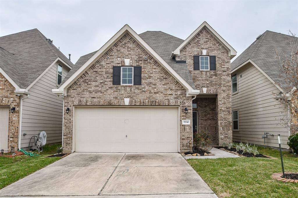 This lovely brick home makes a strong first impression with its clean lines and well-maintained exterior. The attached two-car garage sits neatly alongside a spacious driveway, providing ample room for parking. A walkway extends from the driveway, leading toward the covered entryway tucked to the side. The lush front lawn offers a welcoming stretch of greenery.