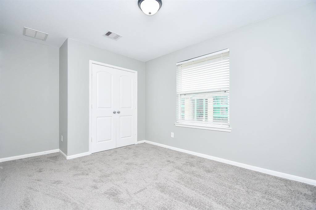 This view emphasizes this fourth bedroom’s open feel, with a generous closet adding practical storage. The window keeps the space bright, making it a welcoming and adaptable part of the home.