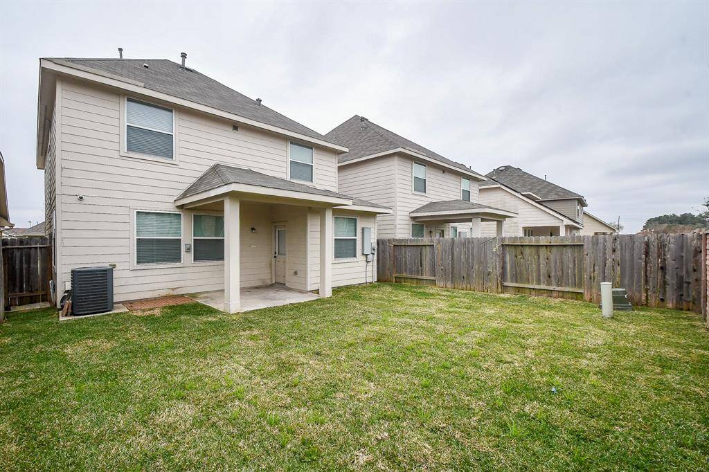 This view showcases the size of the backyard, with ample grassy space that could accommodate outdoor activities, gardening, or even future landscaping projects.