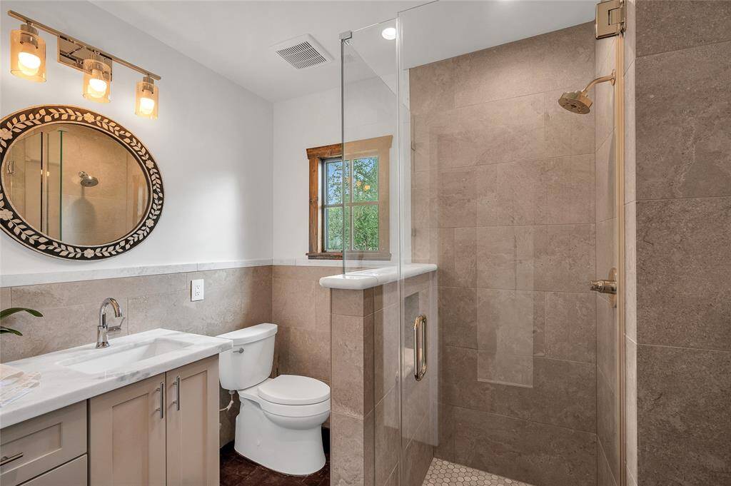 One of 2 primary bathrooms with a large walk-in shower and skirted toilet