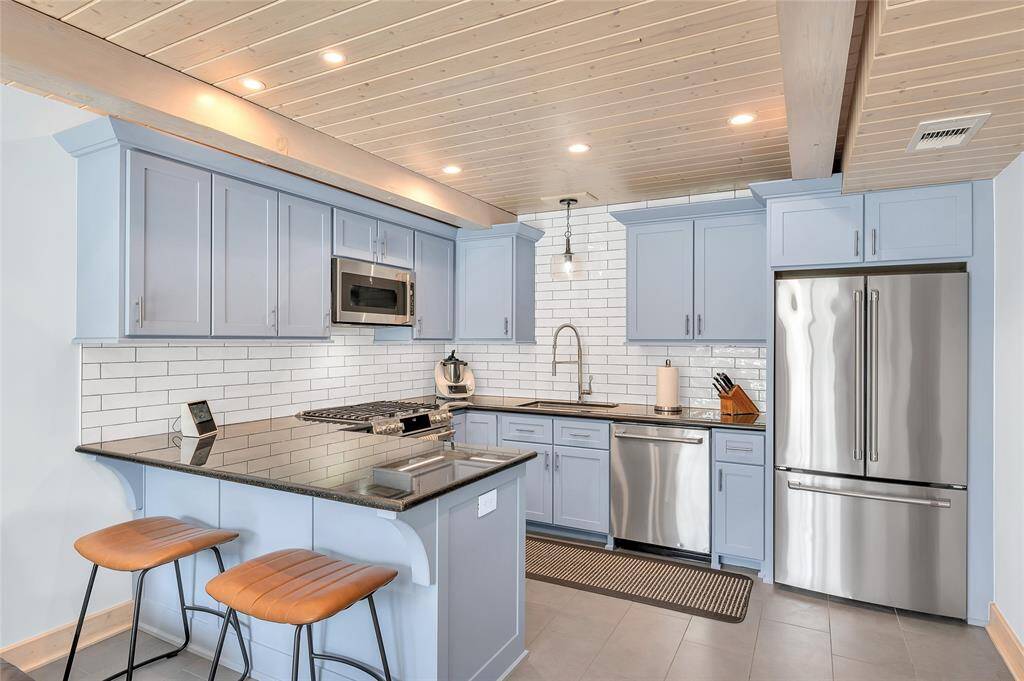 Another view of the kitchen showing the quaint breakfast bar