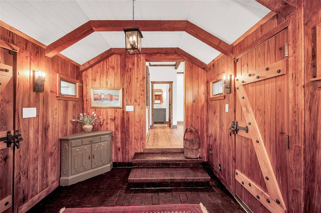 Dramatic front entry with original brick flooring, gorgeous beams, solid wood doors, & cedar coat closet