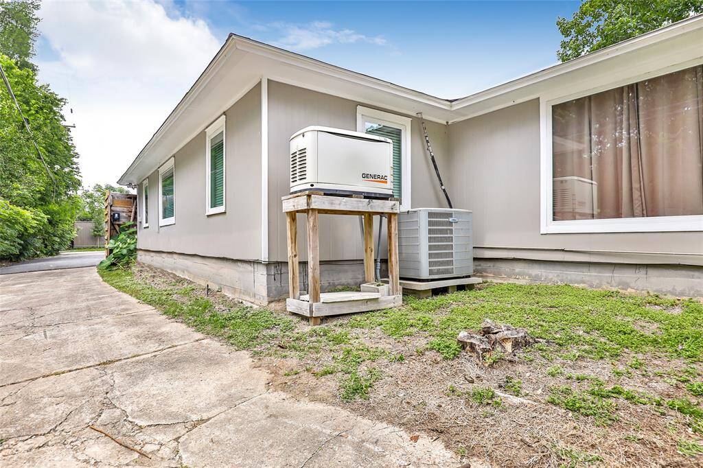 This view is the driveway along the side of the home. Please note the full house generator.