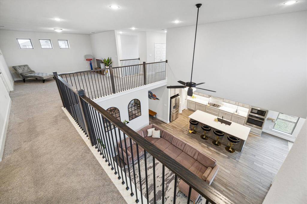 This home features a spacious, modern open floor plan with a high ceiling and loft area overlooking the main living space.  Natural light floods the area, creating a bright and inviting atmosphere.