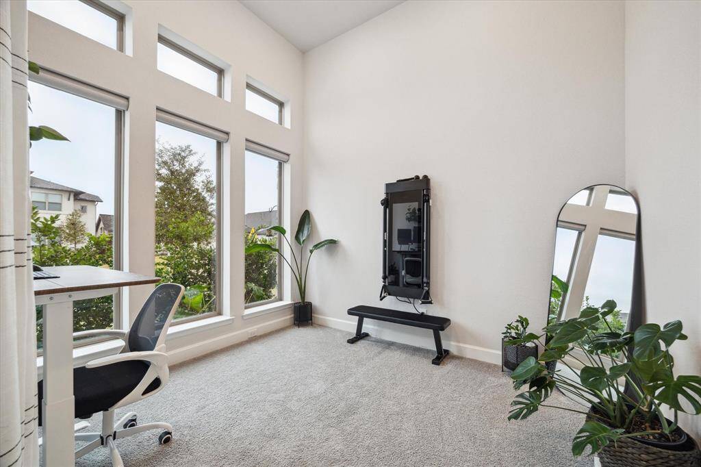 The floor-to-ceiling windows in the home office bring in a lot of natural light—it's perfect for keeping the space bright and airy during the day. The office offers a lovely view of the front yard!