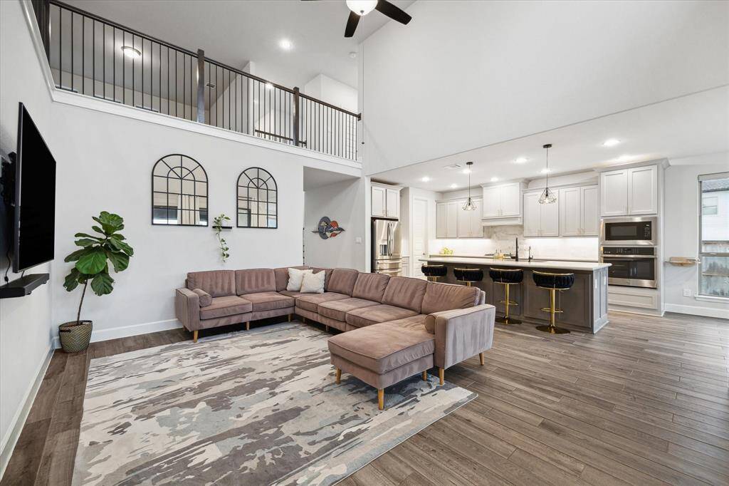 The den, conveniently located adjacent to the kitchen, features upgraded flooring and a modern ceiling fan.