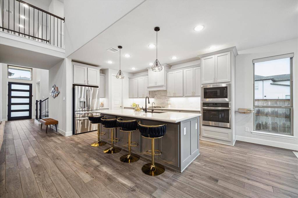 The gorgeous kitchen boasts a large island, perfect for meal prep or casual dining, and is designed for both functionality and style.