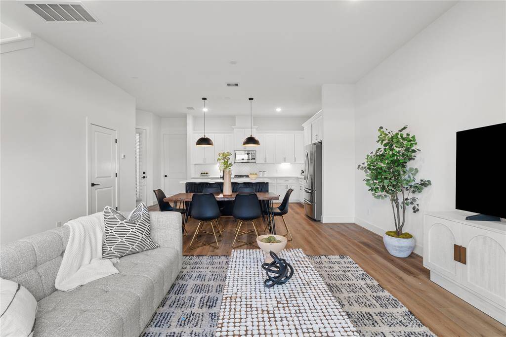 The airy layout is enhanced by high ceilings and strategically placed recessed lighting, creating a bright and inviting atmosphere.
