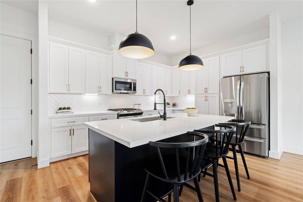 A perfect combination of natural light, warm LVP flooring, and a bold contrast of black and white design elements make this kitchen a showstopper in any home.