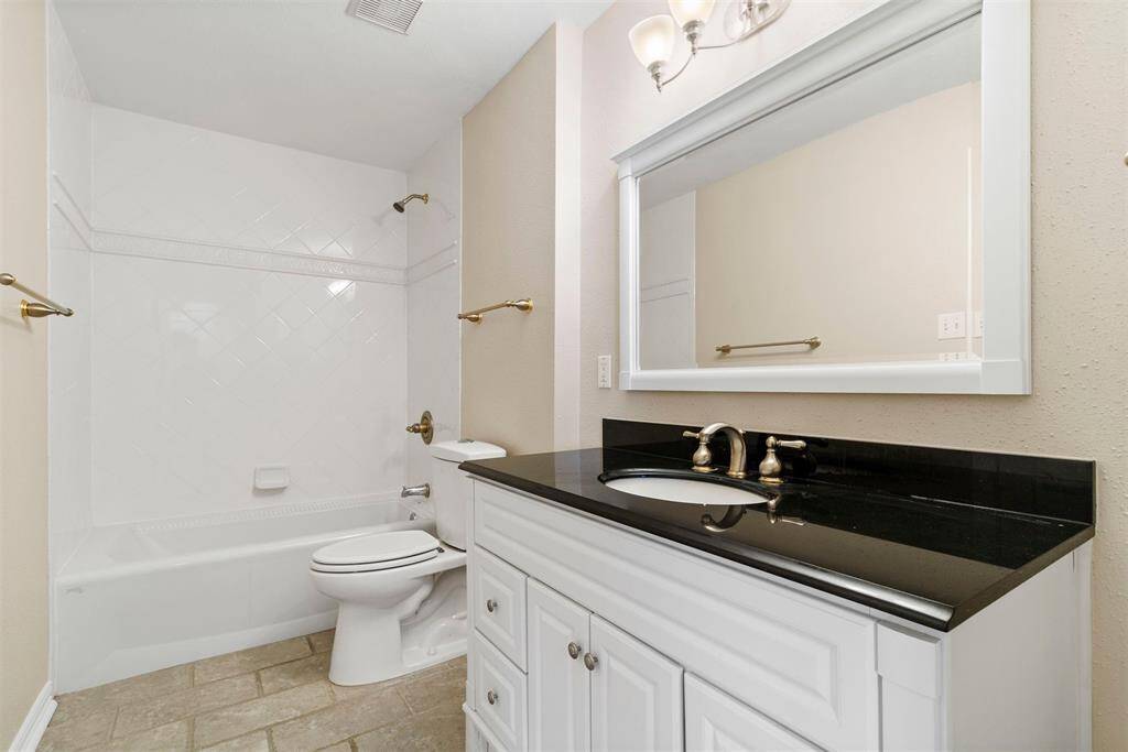 This bathroom offers a white bathtub with an overhead shower and double access from the bedroom and the hallway for guests.