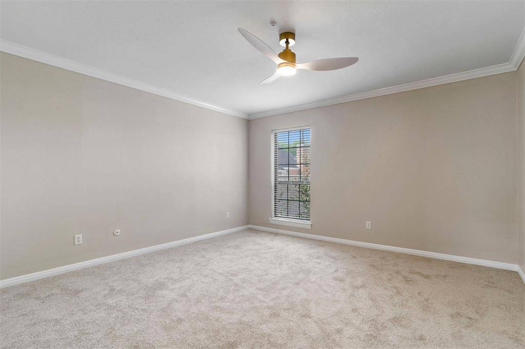 This secondary bedroom with neutral walls, beige new carpeting, and a new ceiling fan. It features a large window that allows for natural light.