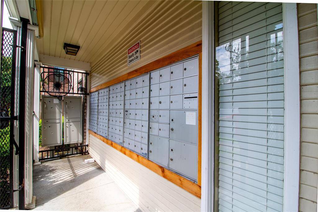 This is an image of a communal mailbox area in an apartment complex, featuring a secure entry and a large bank of individual mailboxes for residents.