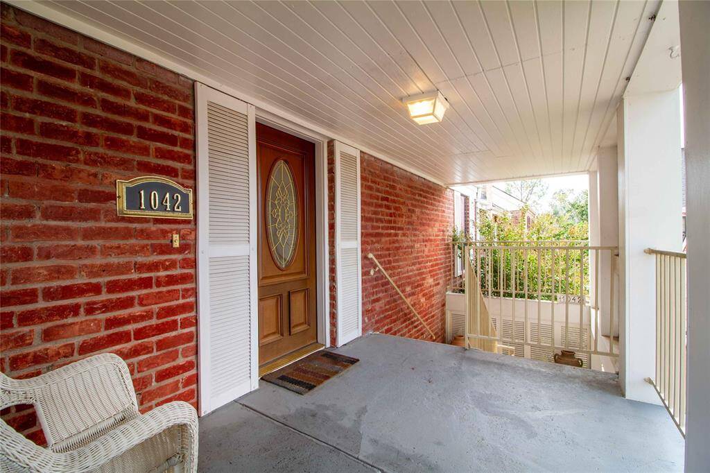 This is a cozy covered entrance with a porch opens to the outside, offering a view of the surrounding greenery.