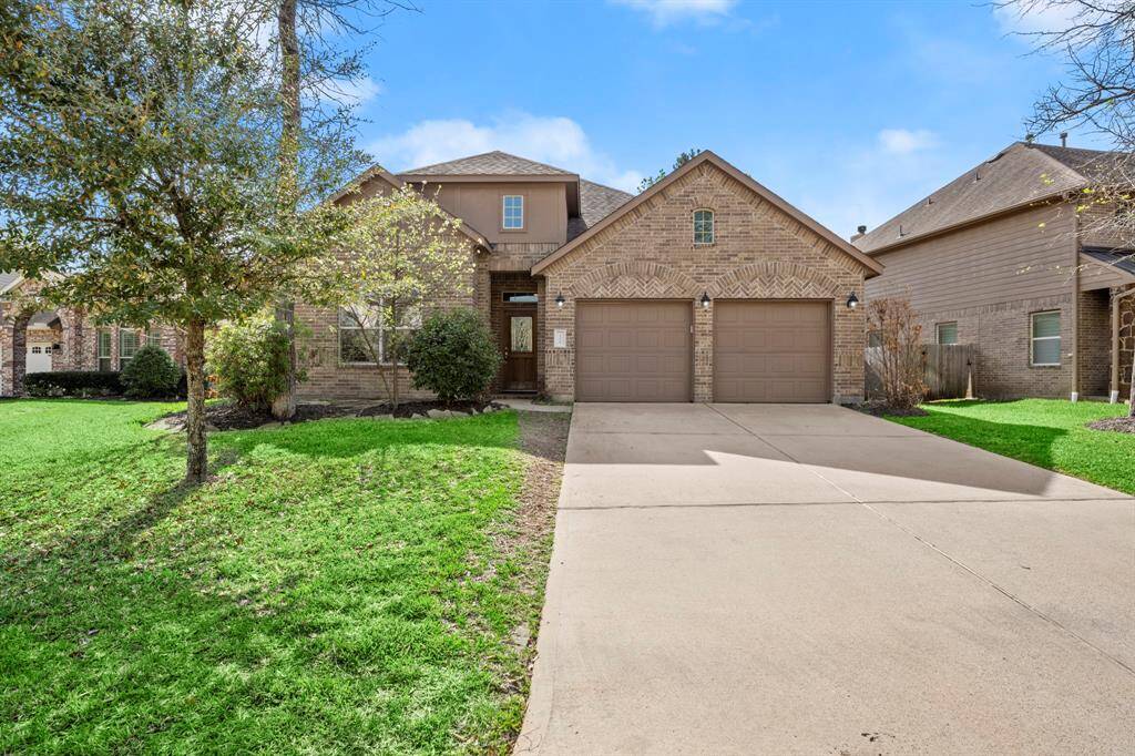 This is a charming brick home with a three-car garage. It features mature trees and a spacious driveway. The exterior has a classic design, offering great curb appeal.