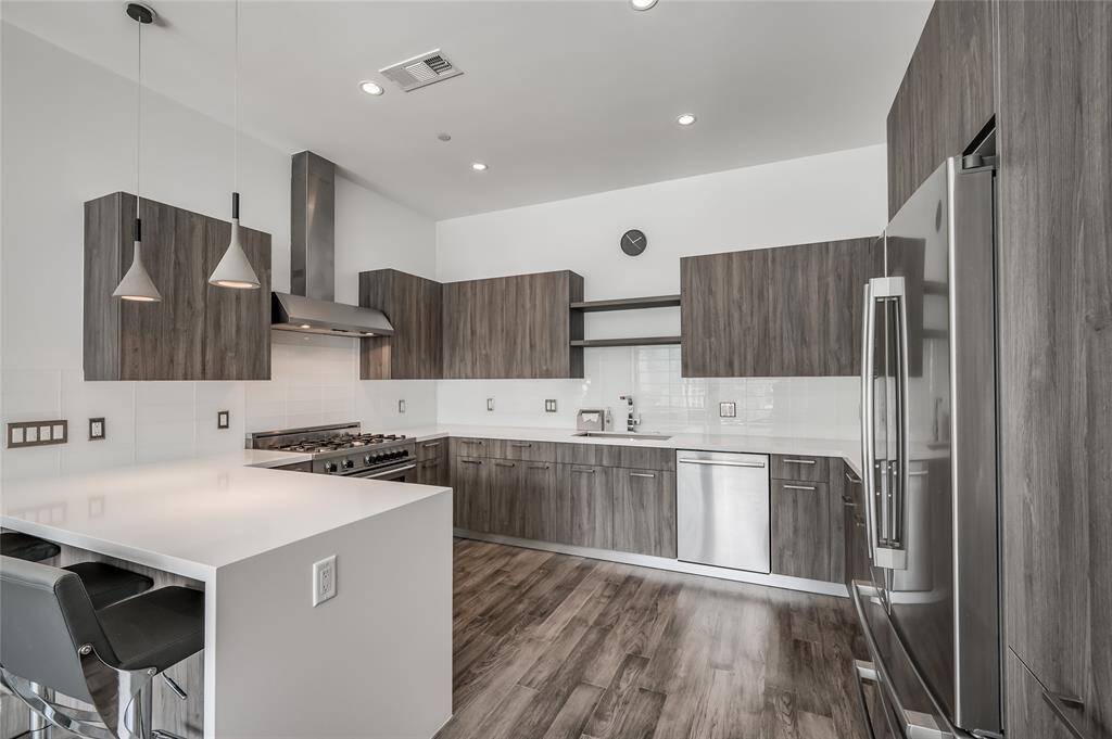 The kitchen boasts stunning quartz countertops that complement the sleek, high-end stainless steel appliances. Designed for both style and function, it includes gas cooking for precise and efficient meal preparation. This space is perfect for both everyday use and entertaining, offering a modern aesthetic with top-tier finishes.