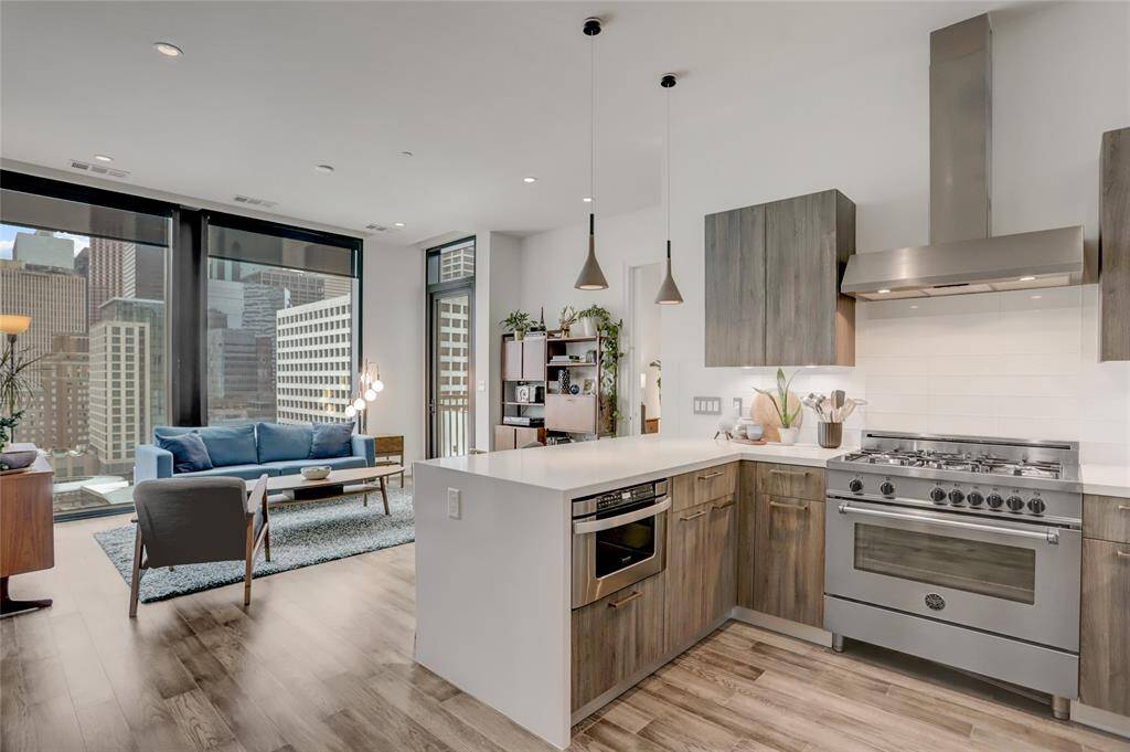 From the kitchen, the open layout flows into the living space, creating an inviting atmosphere perfect for entertaining. The design allows for easy interaction between both areas, with plenty of room for guests to gather while enjoying the stylish and functional kitchen.