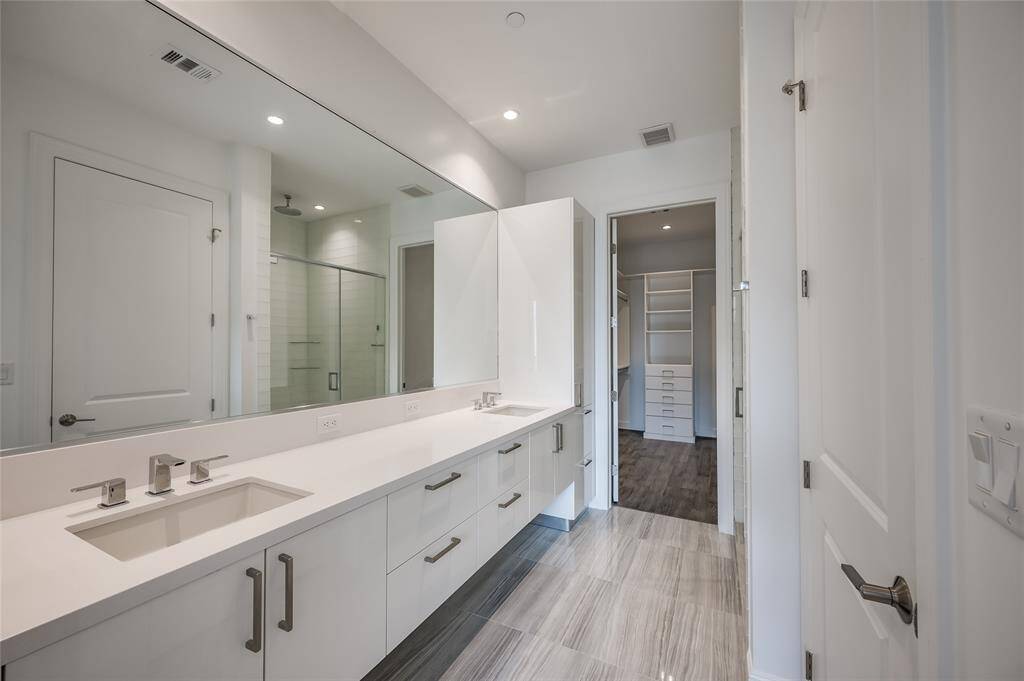 The secondary bathroom features a modern floating double vanity, offering both style and ample storage capabilities. Thoughtfully designed, it provides plenty of space for organization while maintaining a clean, sleek look.