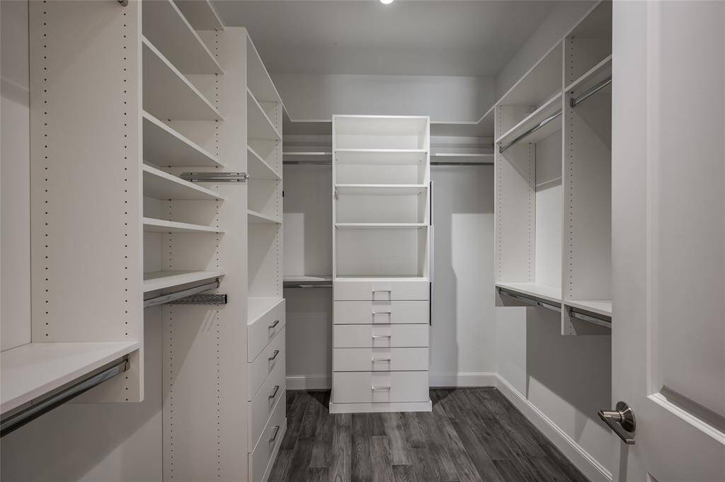 The closet offers an abundance of space, featuring custom cabinetry by Spaceman Company. This thoughtfully designed storage solution maximizes both organization and capacity, making it easy to keep your wardrobe neatly arranged.
